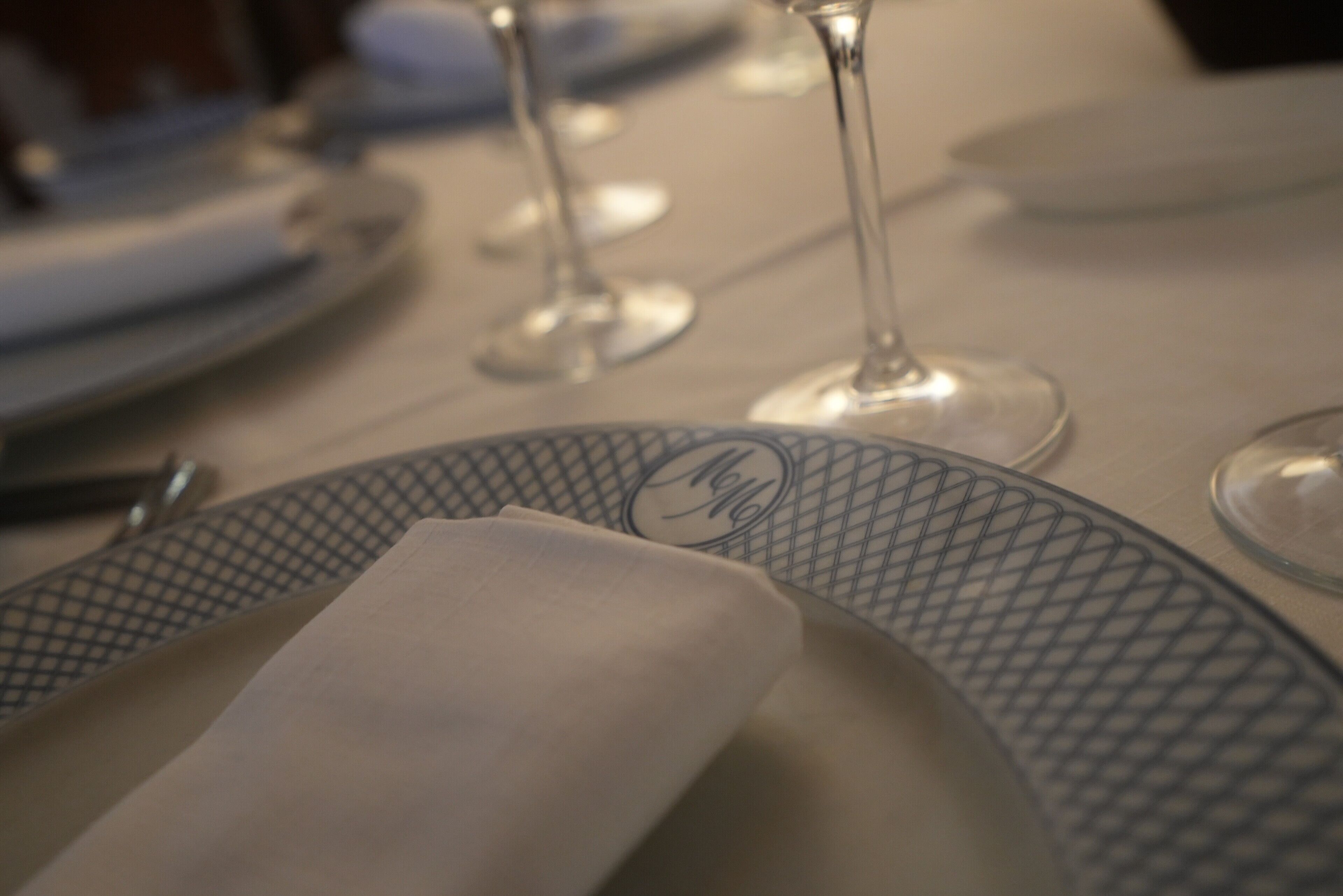 A table set with plates, glasses, and a napkin.