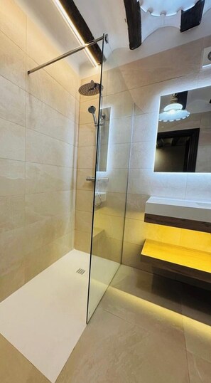 A modern bathroom with a glass-enclosed shower, a white sink, and a yellow countertop.