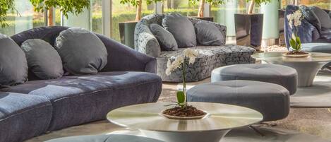 A modern living room with a sectional sofa, ottomans, and a coffee table.