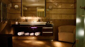 A modern bathroom with a large mirror, a vanity with a sink, and a chair.