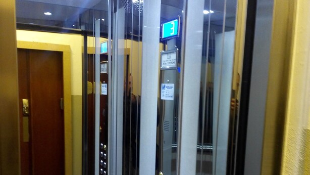 An elevator interior with metallic walls, a glass door, and a digital display indicating the floor number. - Cittadella (Verona)