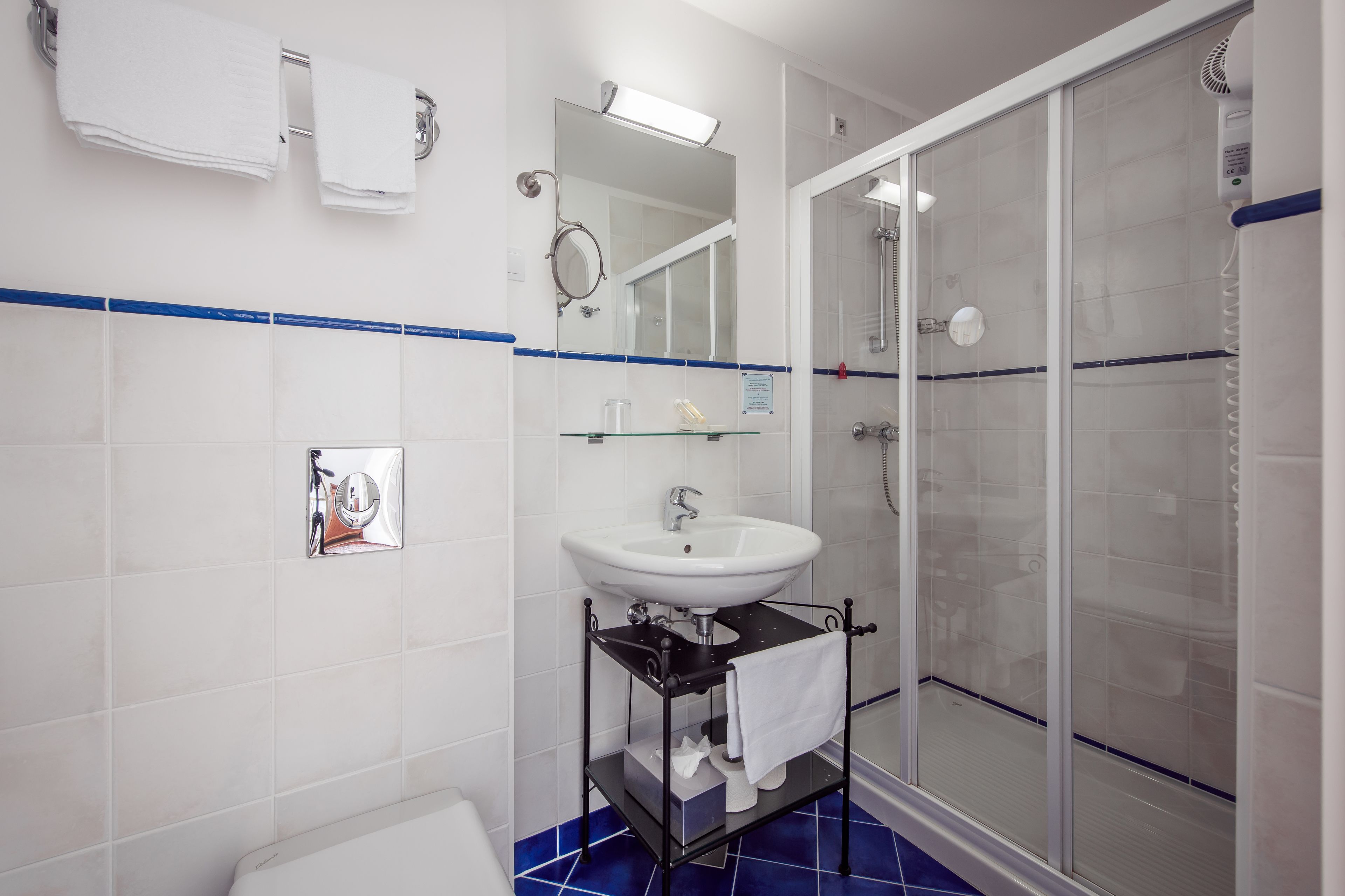 Een moderne badkamer met een wit wastafelmeubel, spiegel en douchecabine.