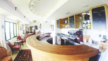 A modern bar area with a curved wooden counter, a coffee machine, and a chalkboard sign reading "Welcome to Wine Club".