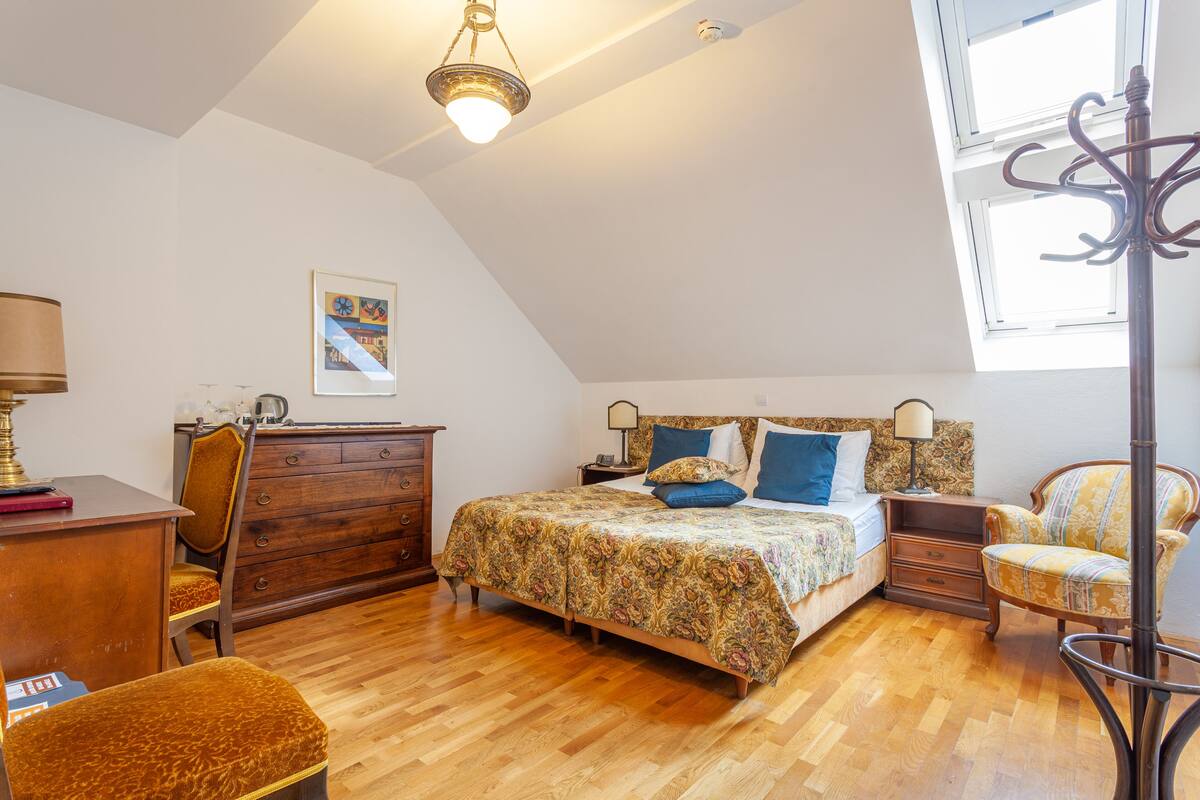 A bedroom with a bed, a dresser, a chair, and a desk.