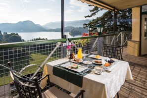 A table set for breakfast with a view of a lake and mountains. - Triglav Bled (Bled)