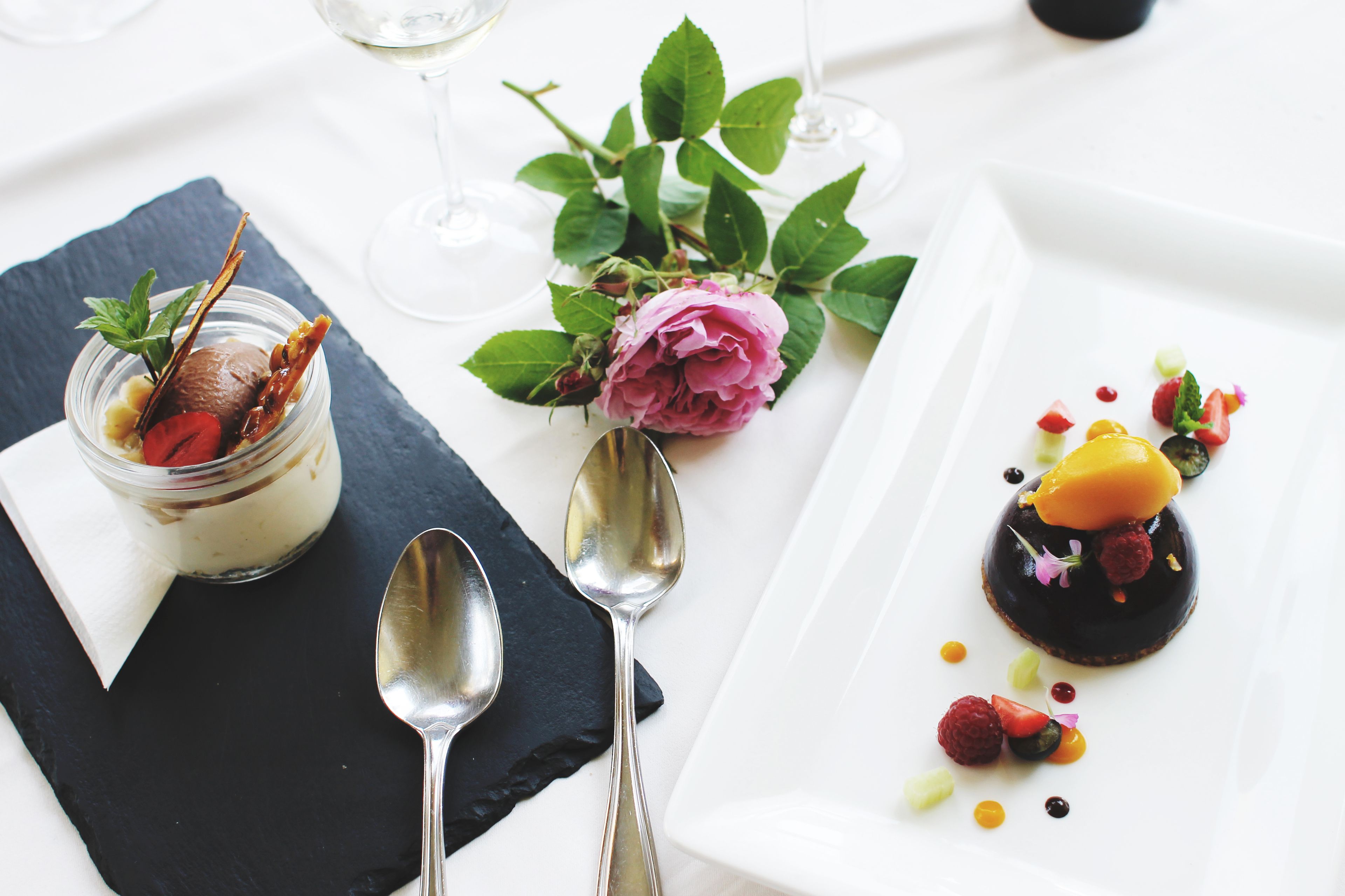 Een dessertborden met chocolademousse, frambozen en mango op een wit bord.