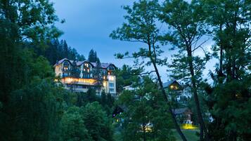 A large, multi-story building surrounded by dense forest.