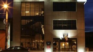A modern building with large windows and a car parked in front. - Maxim Oradea (Oradea)