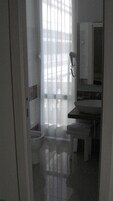 A bathroom with a toilet, sink, and mirror.