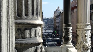Vista de una calle con arquitectura clásica, que incluye columnas y balaustradas.