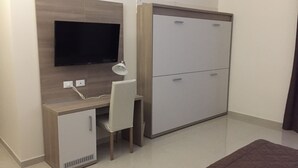 Un dormitorio pequeño con una cama, una mesita de noche y un armario.