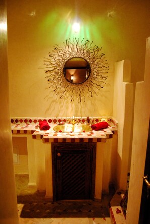 Un baño con un espejo decorativo, un lavabo con salpicadero de azulejos estampados y un perchero para toallas.