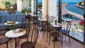 Un salón de hotel con asientos, mesas y plantas en macetas.