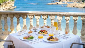 A table set with breakfast items overlooking a coastal view.
