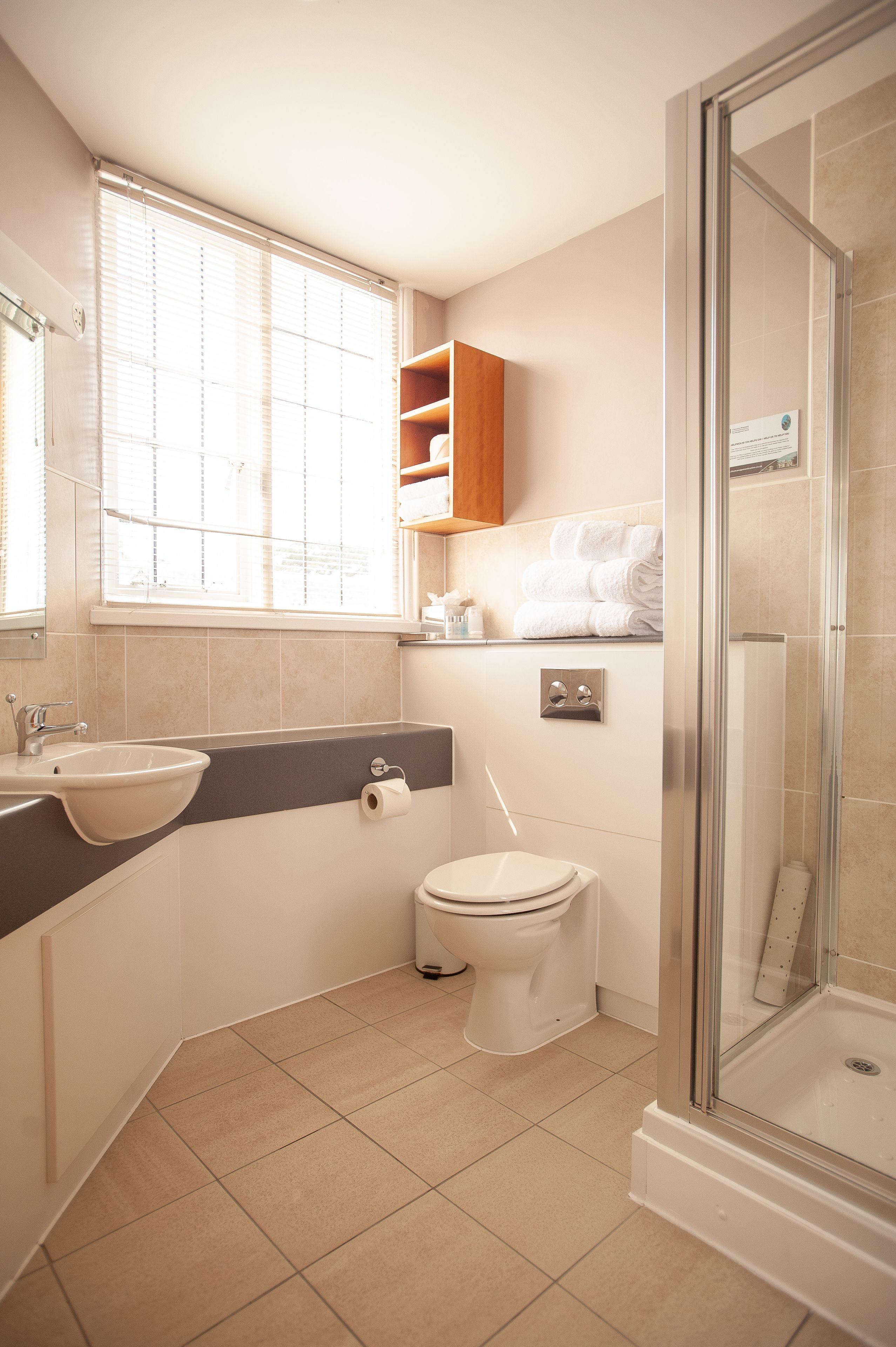 A modern bathroom with a sink, toilet, and shower.