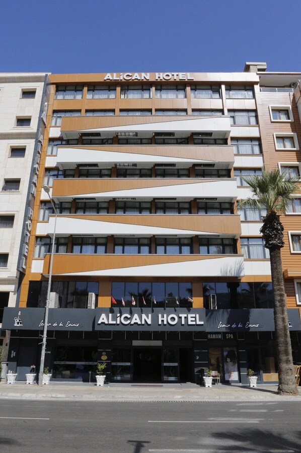 Et moderne hotel med flere etager, altaner og store vinduer.