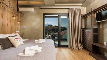 Una habitación de hotel moderna con una cama grande, una televisión de pantalla plana y una puerta corrediza de vidrio a un balcón.