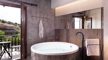 Ein modernes Badezimmer mit einer freistehenden Badewanne, einem hölzernen Waschtisch, einem großen Spiegel und einem Handtuchhalter.