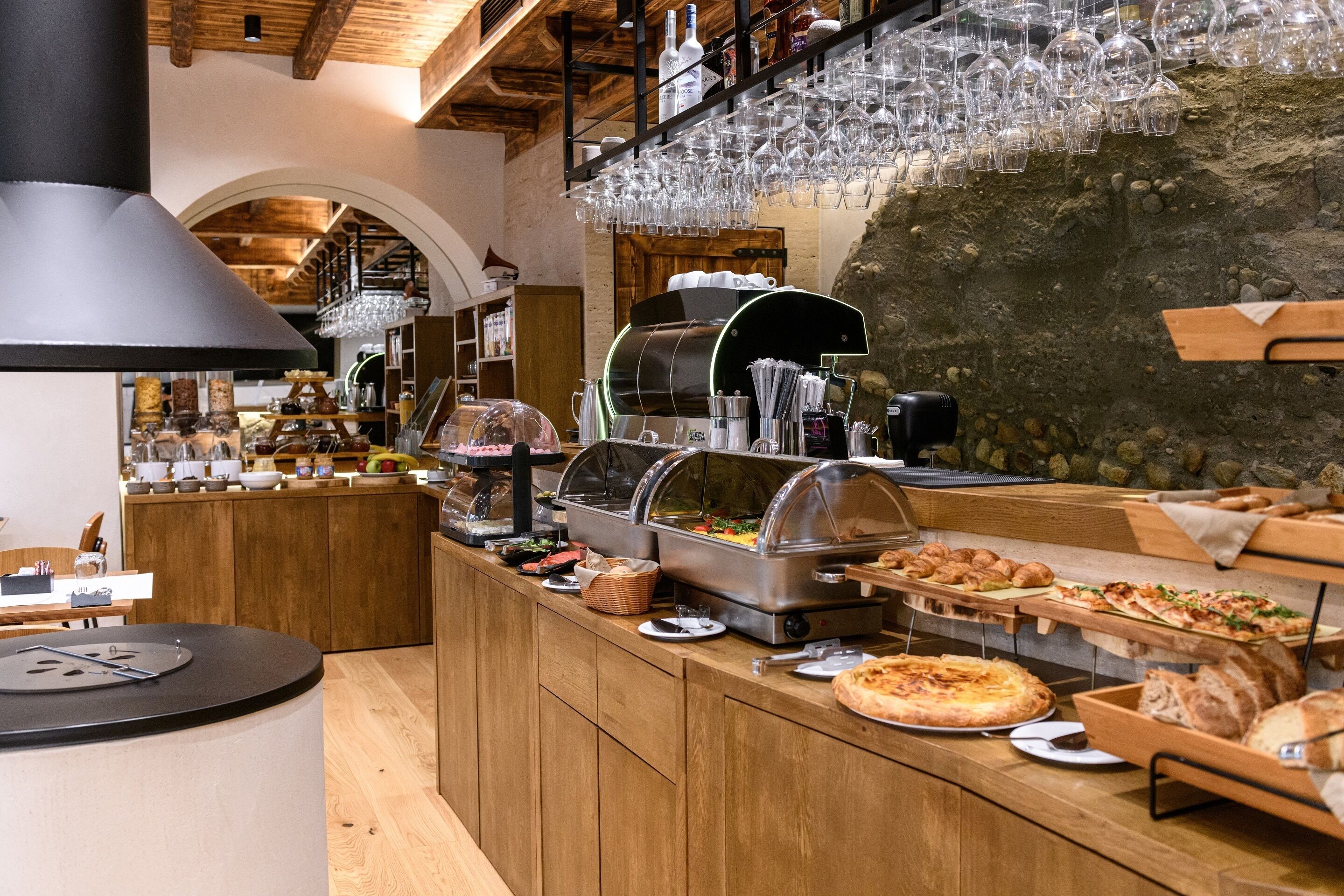 Ein Buffetbereich mit verschiedenen Speisen, einer Kaffeestation und einer Weinauslage.