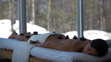 Guests can enjoy a rejuvenating hot stone massage in a serene spa setting with a tranquil view.
