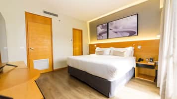 Una habitación de hotel con cama, mesita de noche y escritorio.
