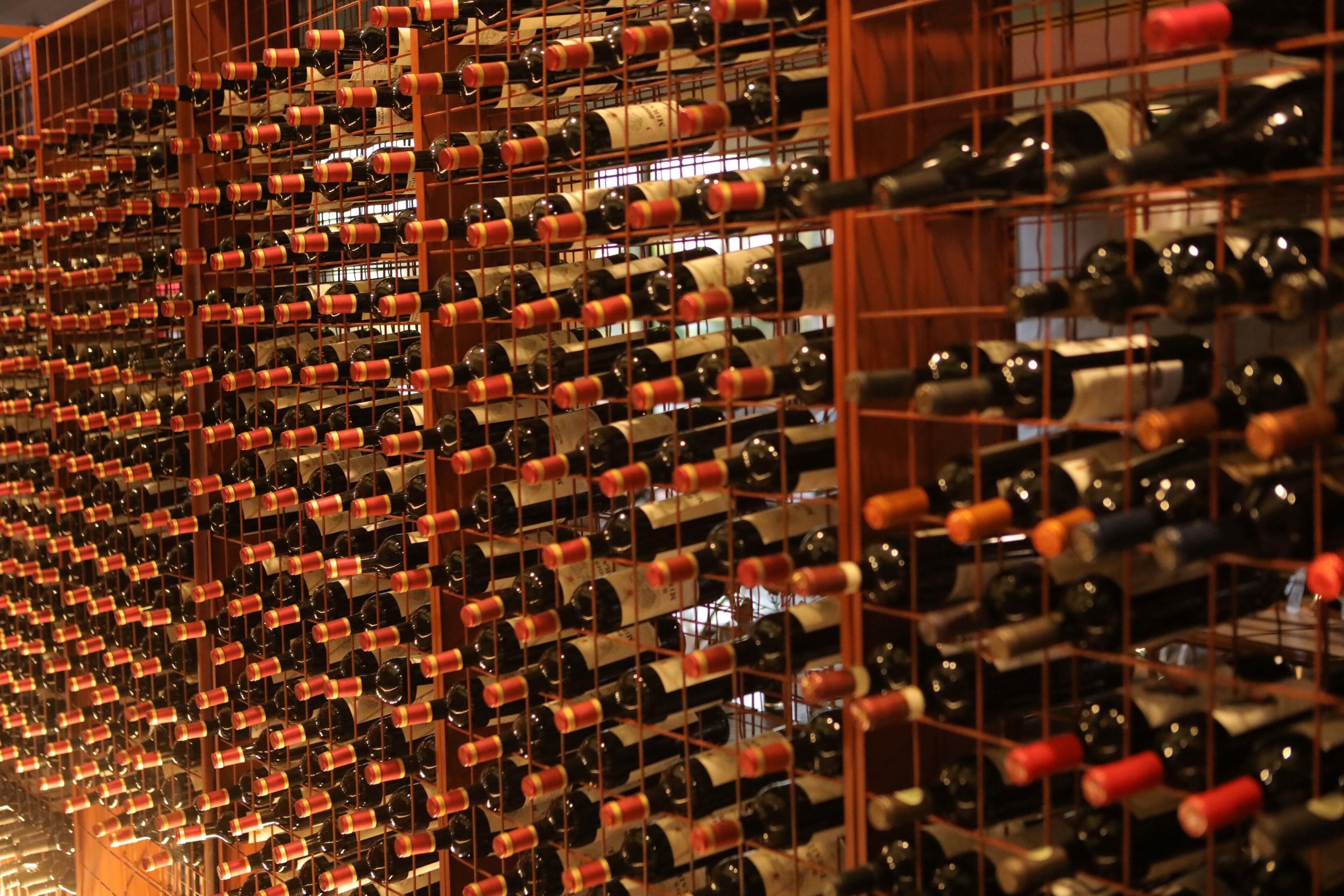 A wine cellar with numerous bottles organized in a grid pattern on racks.