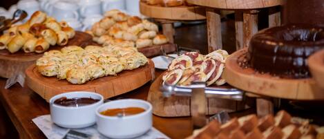 A buffet with various baked goods and dips.