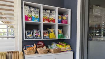 Ein Verpflegungsregal mit verschiedenen, verpackten Snacks und einem weißen Schrank darunter.