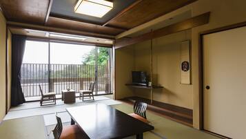 Habitació japonesa tradicional amb sòls de tatami, una taula baixa i cadires.