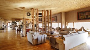 A spacious living area with wooden flooring and furniture, including sofas and a coffee table.