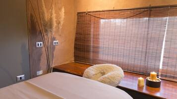 Relax in a serene space with a plush bed, soft pillow, and warm candlelight.