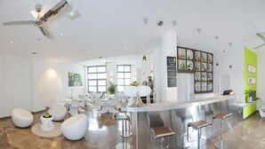 Un hall d’hôtel moderne avec un bar, des sièges et une grande fenêtre.