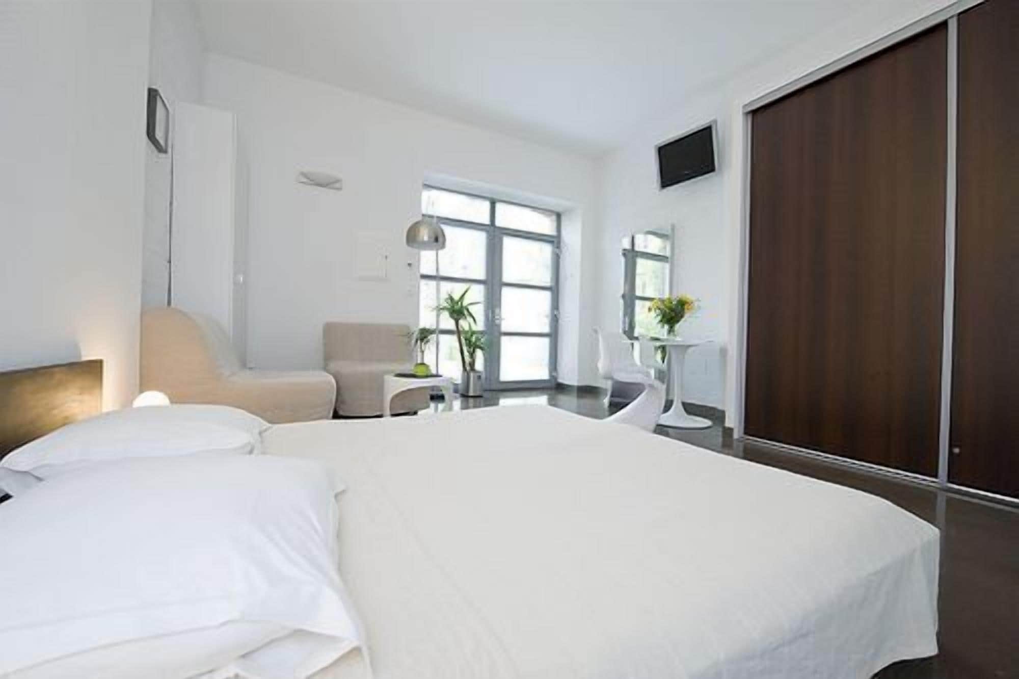 Une chambre d’hôtel moderne équipée d’un grand lit, d’un bureau, d’une chaise et d’une armoire.