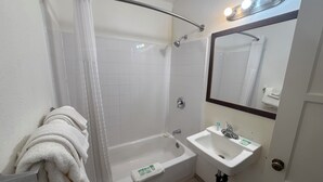 A bathroom with a bathtub, a shower, a sink, and a mirror. - Canyonlands Motor Inn (Monticello)