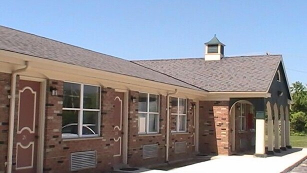 A two-story brick building with a flat roof, large windows, and a covered porch area. - Hometown Inn Galion (Galion)