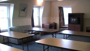 A classroom with desks, a couch, and a television. - Hometown Inn Galion (Galion)