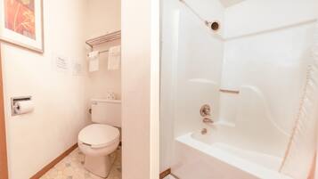 A bathroom with a toilet, a shower, and a sink.