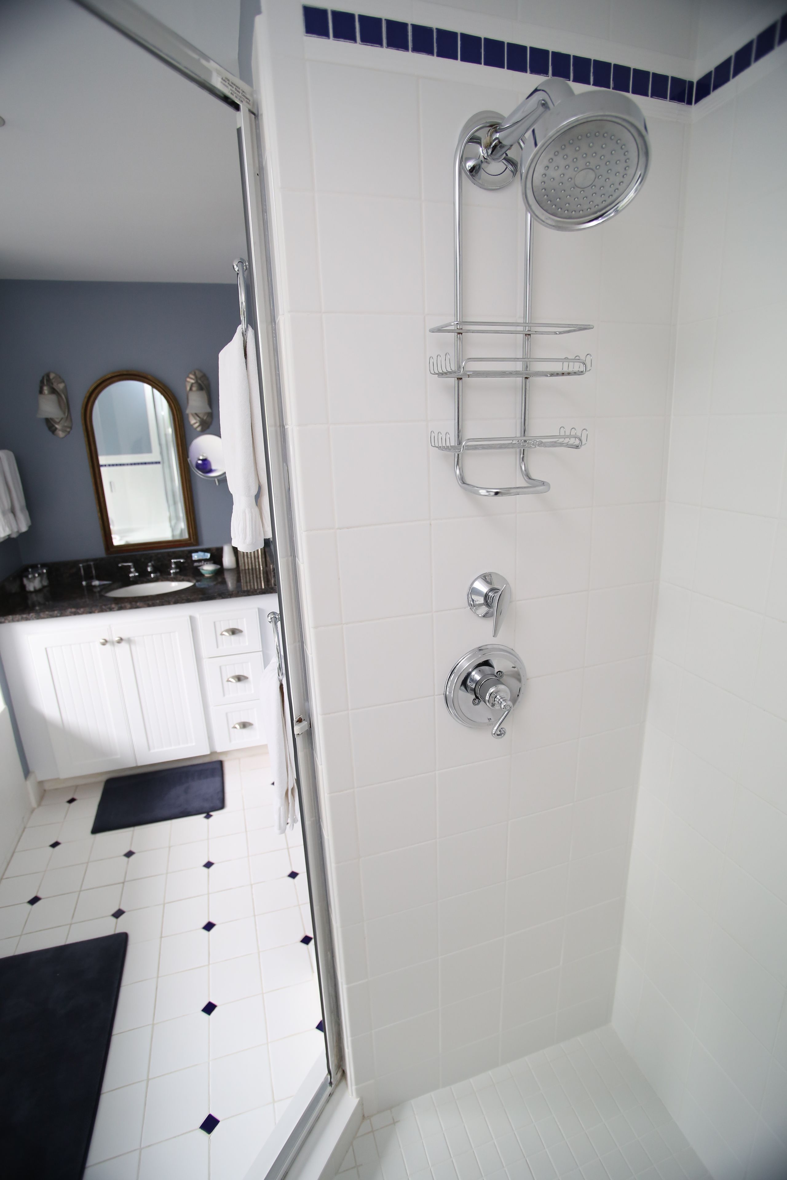 A bathroom with a shower, a sink, and a mirror.