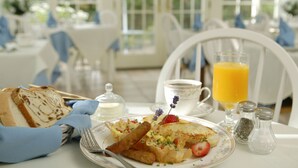 A breakfast setting with a plate of food, a glass of orange juice, and a cup of coffee. - Captain's House Inn (Chatham)