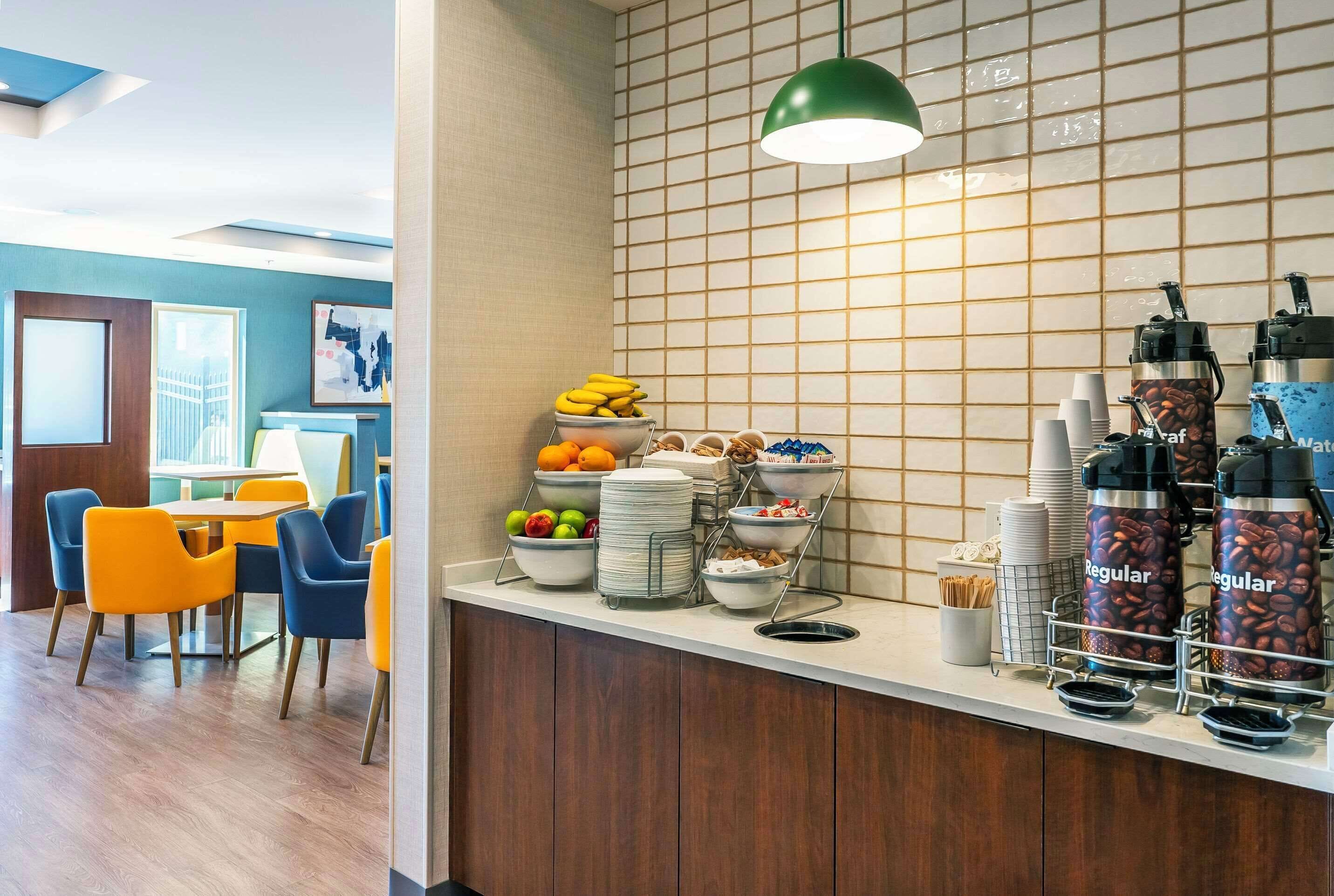 A breakfast bar with various food items and coffee dispensers.