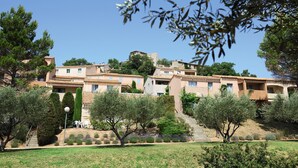 A hillside residential area with terraced houses, a staircase leading up, and a clear blue sky. - Belambra Clubs Montpezat - Le Verdon (Montagnac-Montpezat)