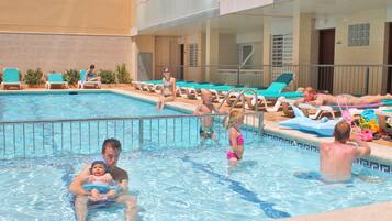 Guests can swim and relax in the hotel's indoor pool surrounded by lounge chairs and sunbeds.