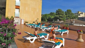 A rooftop pool area with lounge chairs and potted plants. - Apartamentos Costa d'Or (Calafell)
