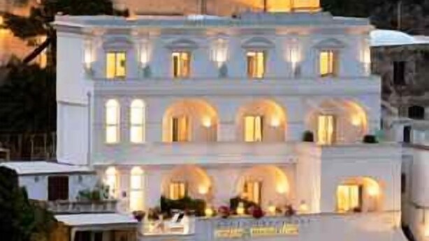 A multi-story building with a prominent dome and a series of balconies. - Palazzo Marzoli Resort (Positano)