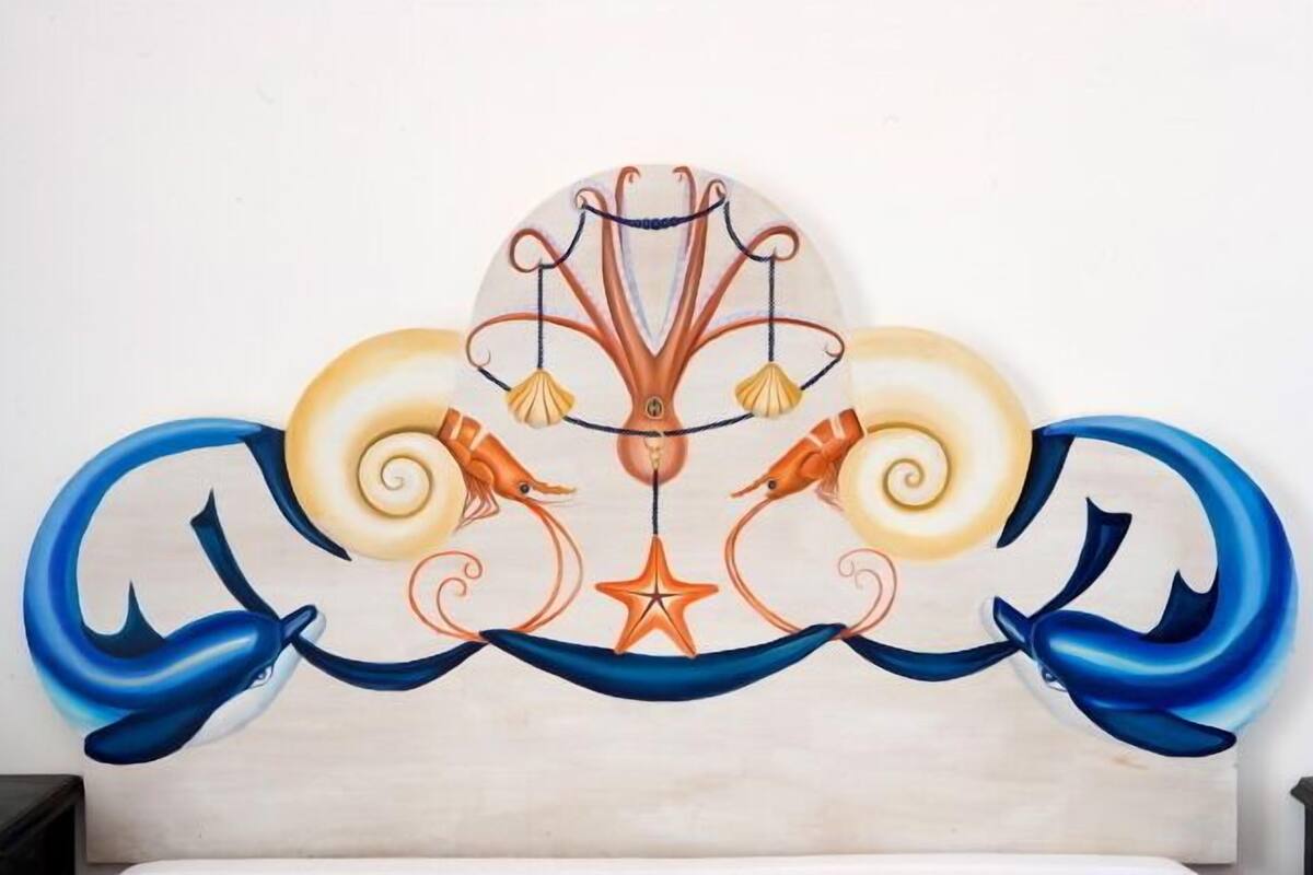 A decorative wall piece with a central tree-like structure, two dolphins, and a star.