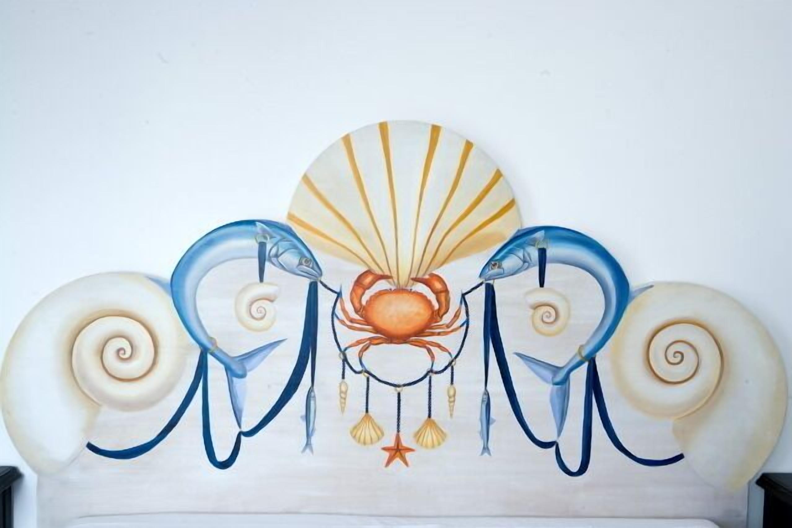 Un mur orné d’une peinture décorative représentant un crabe et des coquillages.