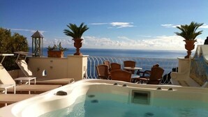 A rooftop pool area with lounge chairs, a hot tub, and a view of the sea. - Palazzo Marzoli Resort (Positano)