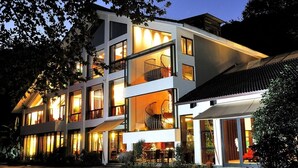 A modern multi-story building with large windows and a central staircase. - Landison Longjing Resort (Hangzhou)