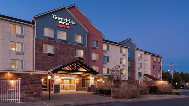 A multi-story hotel with a prominent TownPlace Suites Marriott sign. The building features a mix of brick and modern facade elements, with a covered entrance and visible windows. - TownePlace Suites by Marriott Little Rock West (Little Rock)