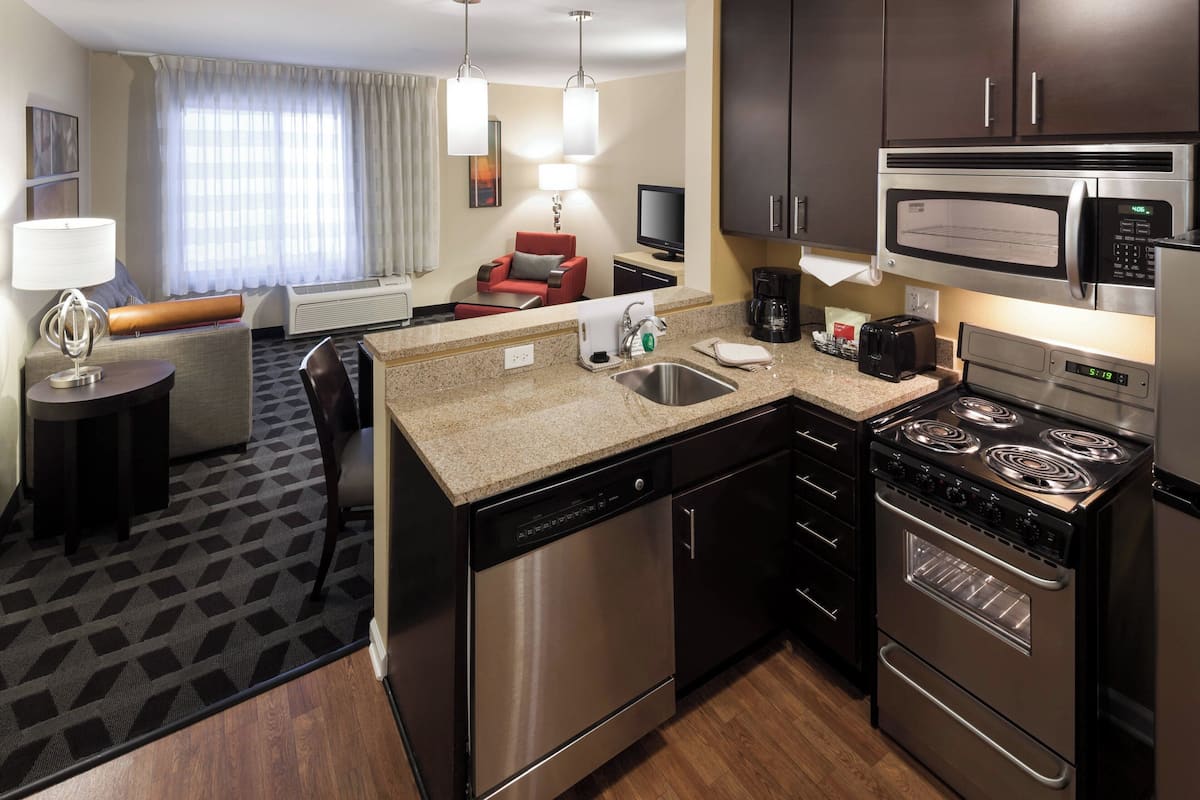 Une cuisine d’hôtel compacte équipée d’un four à micro-ondes, d’une cuisinière et d’un lave-vaisselle.